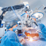 Two surgeons, one female, one male, work under a surgical robot.